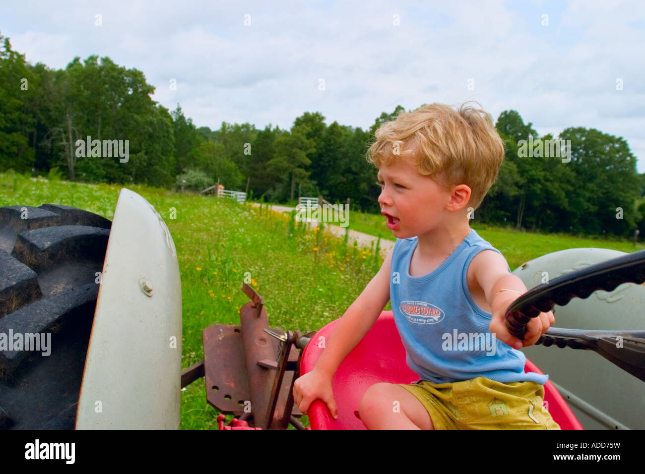 Boy playing on Tractor Stock Photo