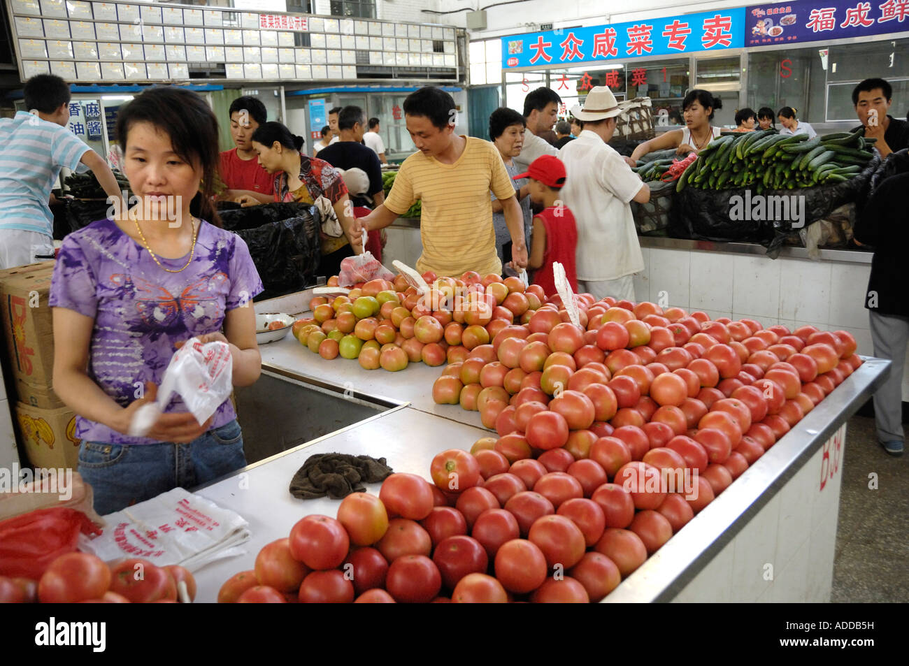 A woman sells tomatos in a food market in Beijing China 13 Aug 2007 Stock Photo