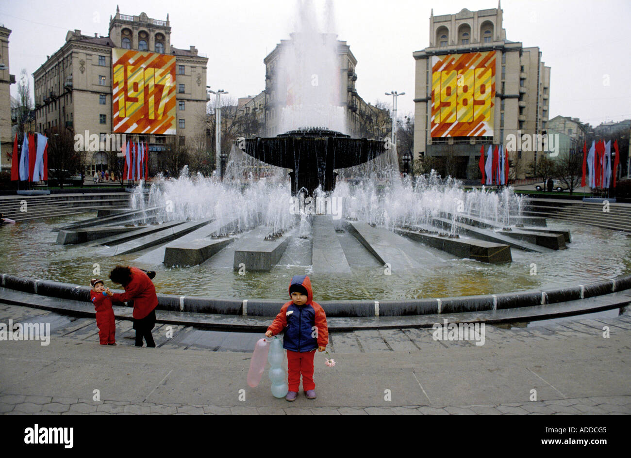 A mother with her children by a fountain in Kiev just before the USSR's Revolution Day parade in Kiev on 7th Nov 1989 celebrating 72 years of the USSR. Stock Photo