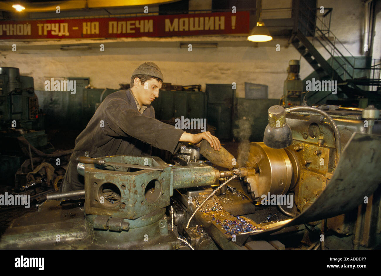 Miner working oiling a lathe in the engineering workshop at the Sots Donbs mine, Donetske, Ukraine. Stock Photo