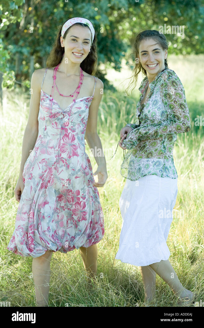Two young women standing in field, smiling at camera Stock Photo - Alamy
