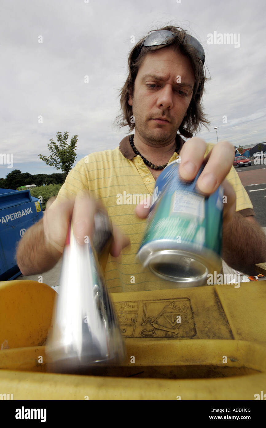 A YOUNG MAN RECYCLING HIS ALUMINIUM CANS AT A SUPERMARKET RECYCLING AREA. Stock Photo