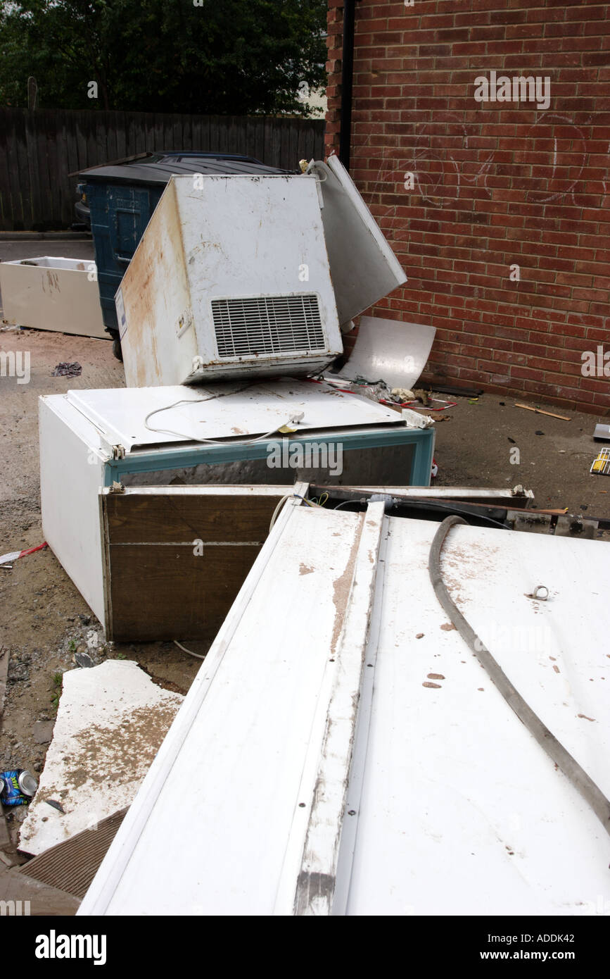 Abandoned fridges and freezers in a back alley behind a parade of shops