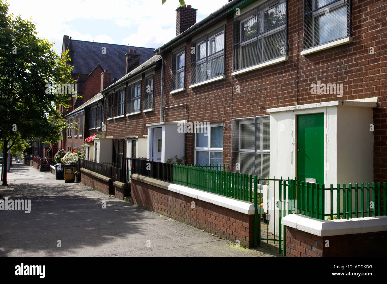 row of red brick terraced houses in inner city urban interface area of belfast with security