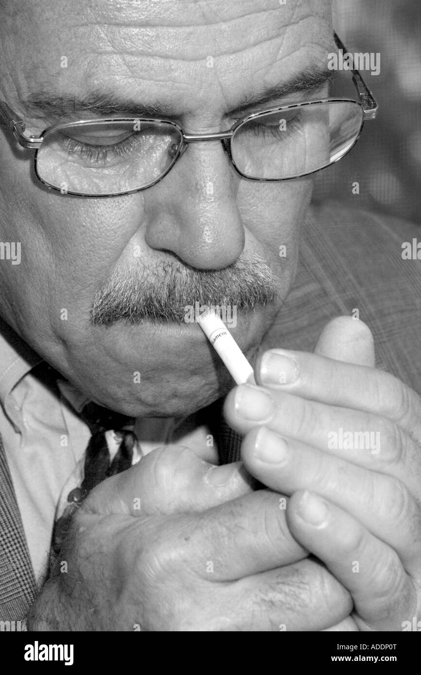 Older White man Lighting a Cigarette Stock Photo