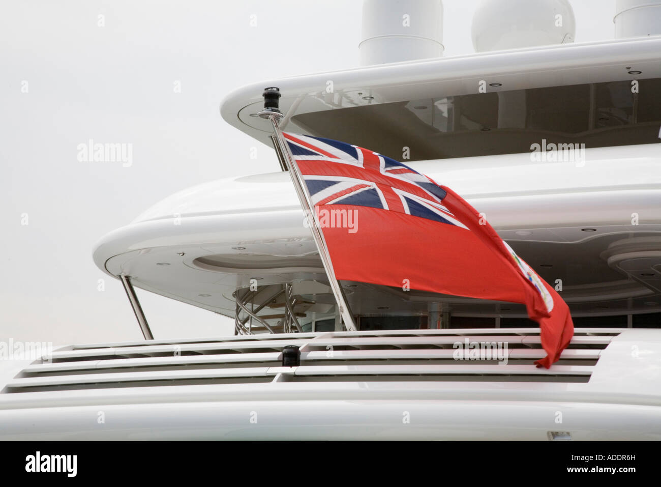 The British Red Ensign flag of the Royal Merchant Navy flies on the stern of a luxury yacht Stock Photo
