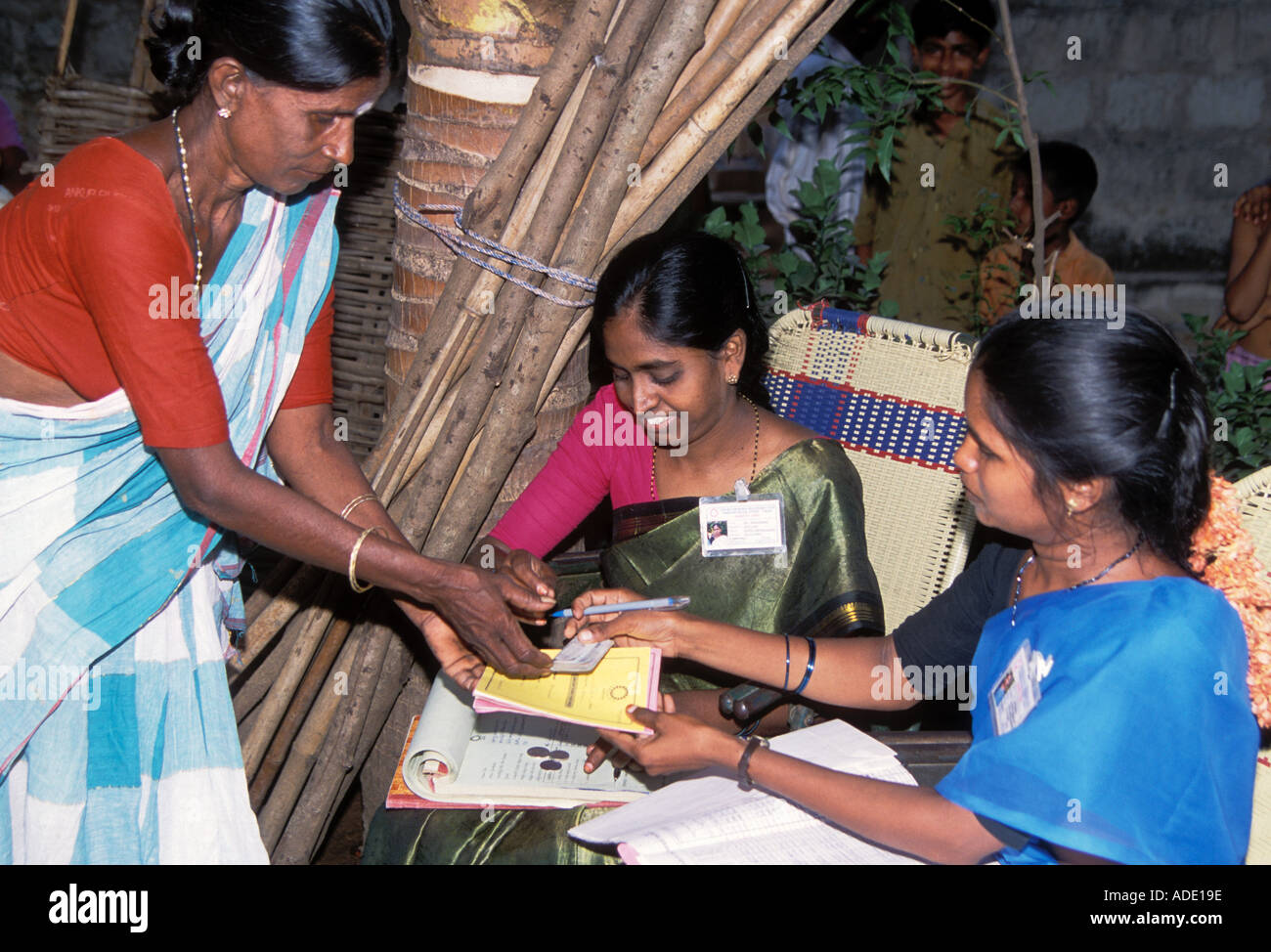 East Indian woman pays back loan for business to two Indian females with bookkeeping duty Stock Photo