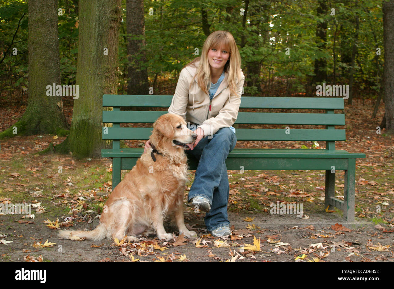 Young girl 16 sitting on a park bench with golden retriever Stock Photo ...