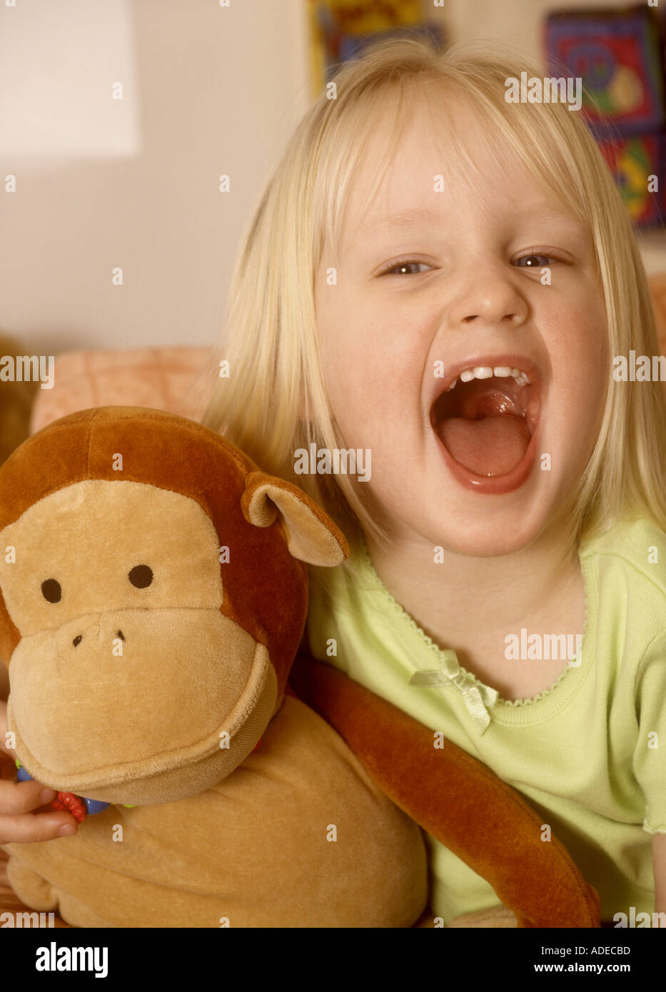 Pretty young girl cuddling a soft toy shouting Stock Photo