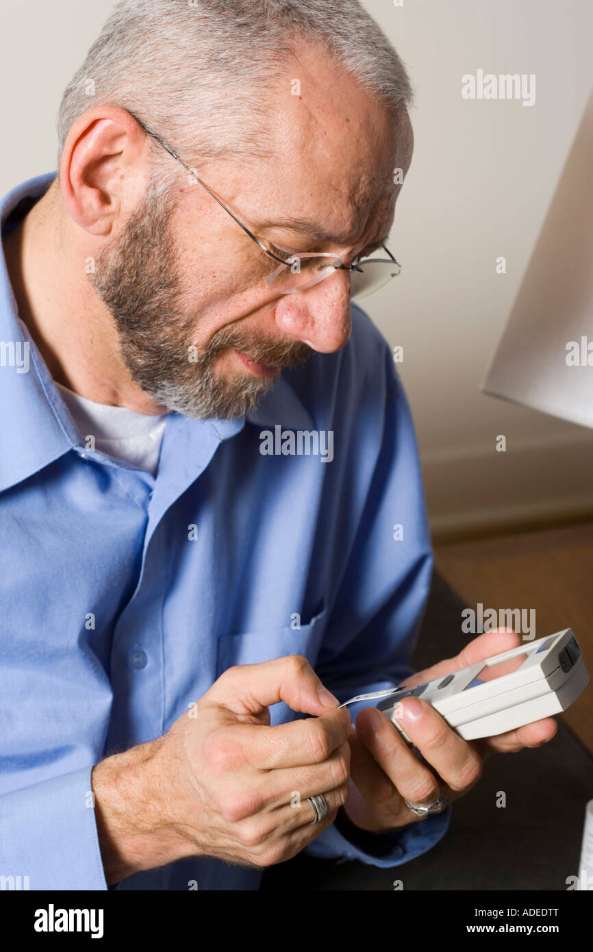 Diabetic patients reads his glucose meter readout. Stock Photo