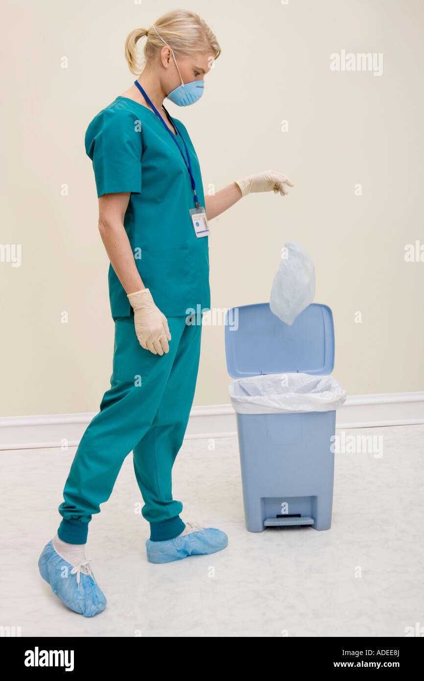 Healthcare worker places disposables into trash Stock Photo Alamy