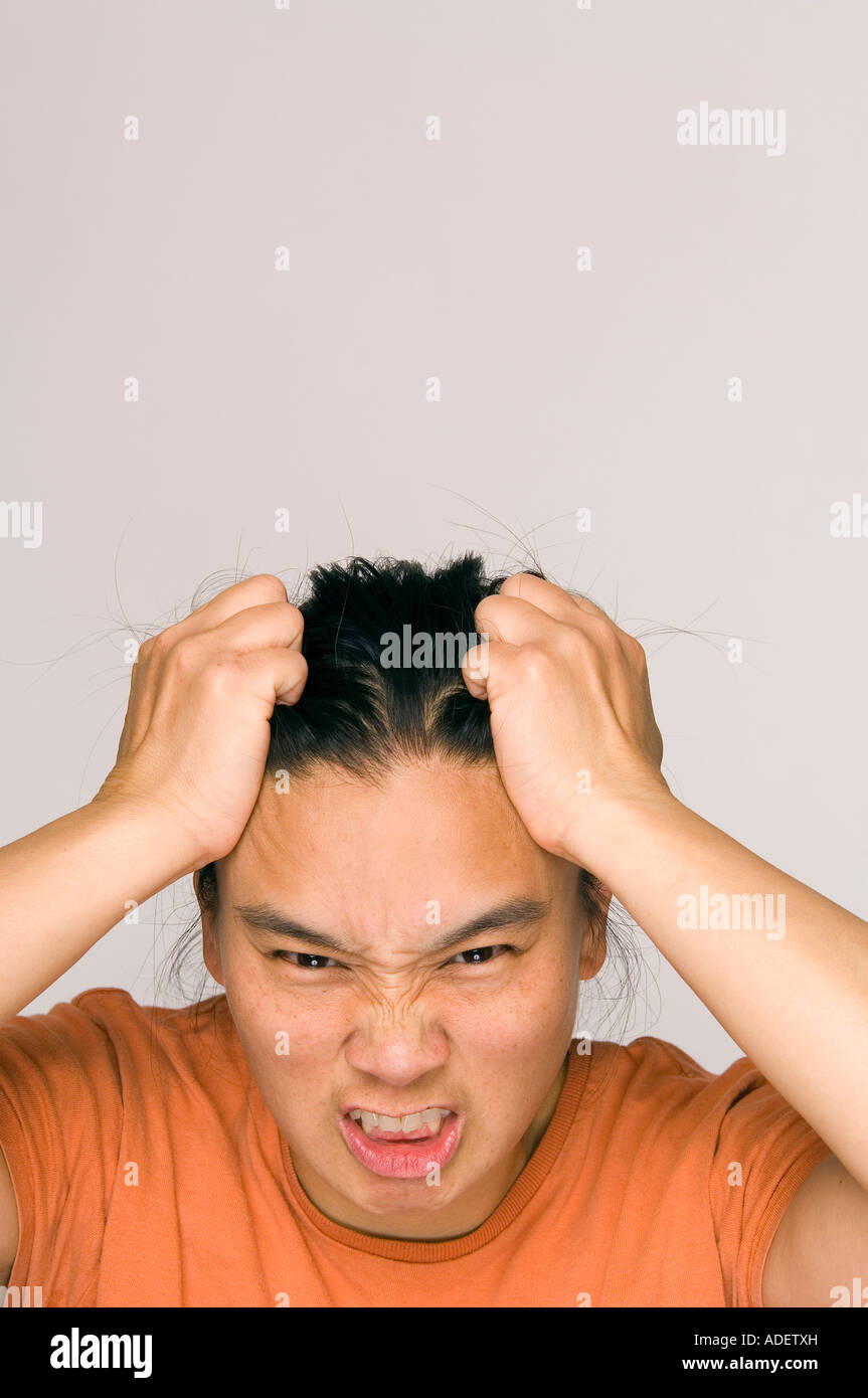 Stressed out Asian woman holding head. Stock Photo