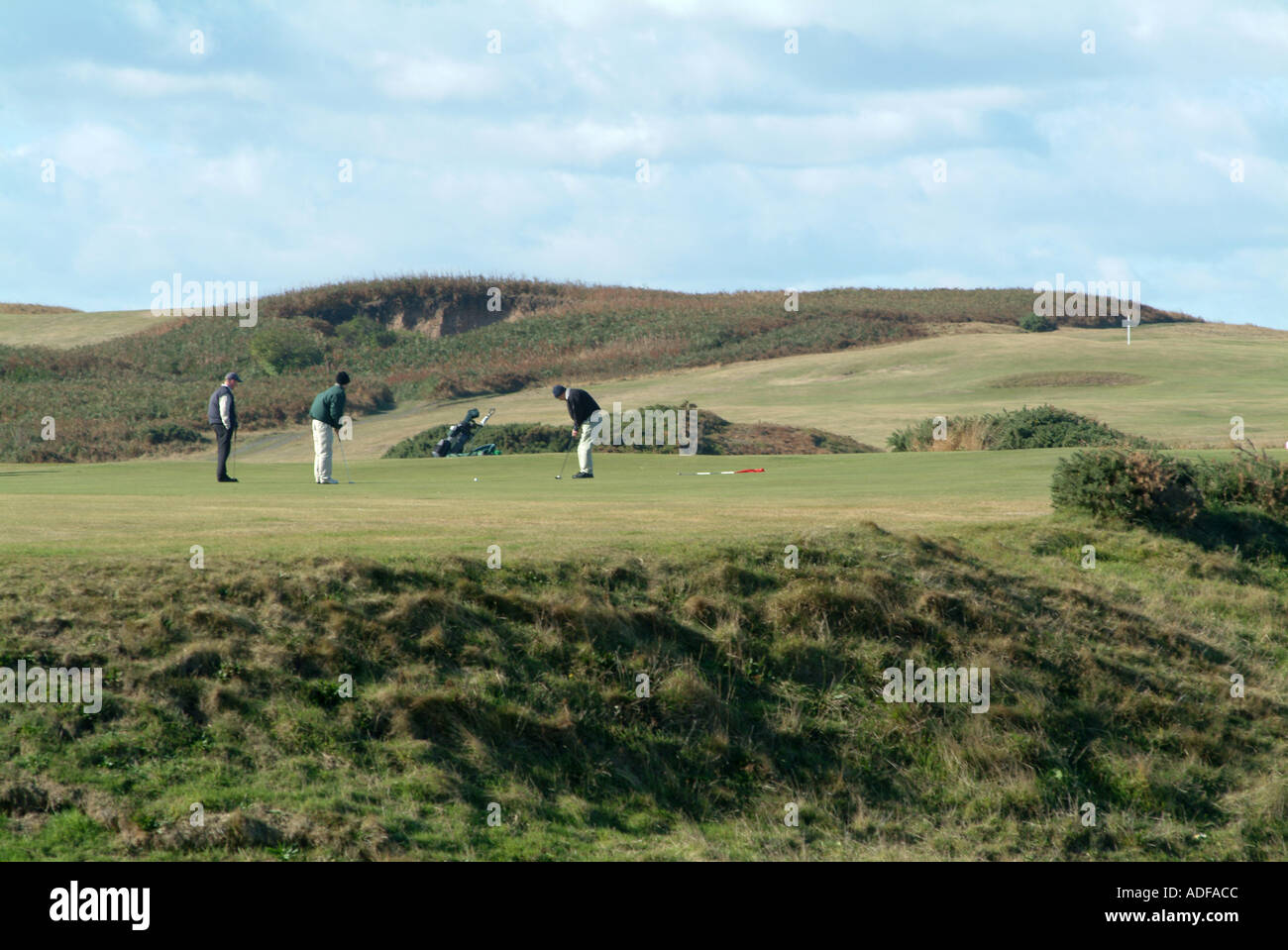 Golfers on First Green at Bamburgh Castle Golf Club Northumberland England United Kingdom UK Stock Photo