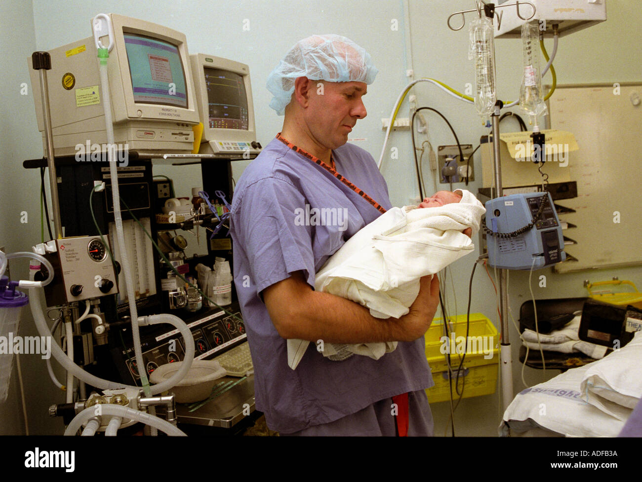 Father with newborn baby following forceps delivery in operating theatre. Stock Photo