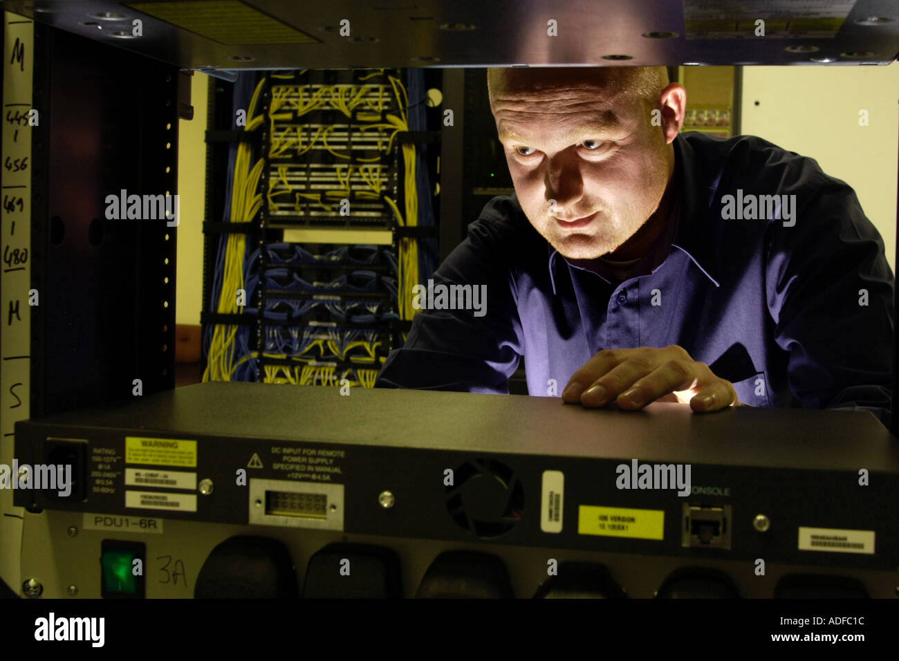 Specialist network engineer checking switching and cabling at telecoms business in Cardiff South Wales UK Stock Photo