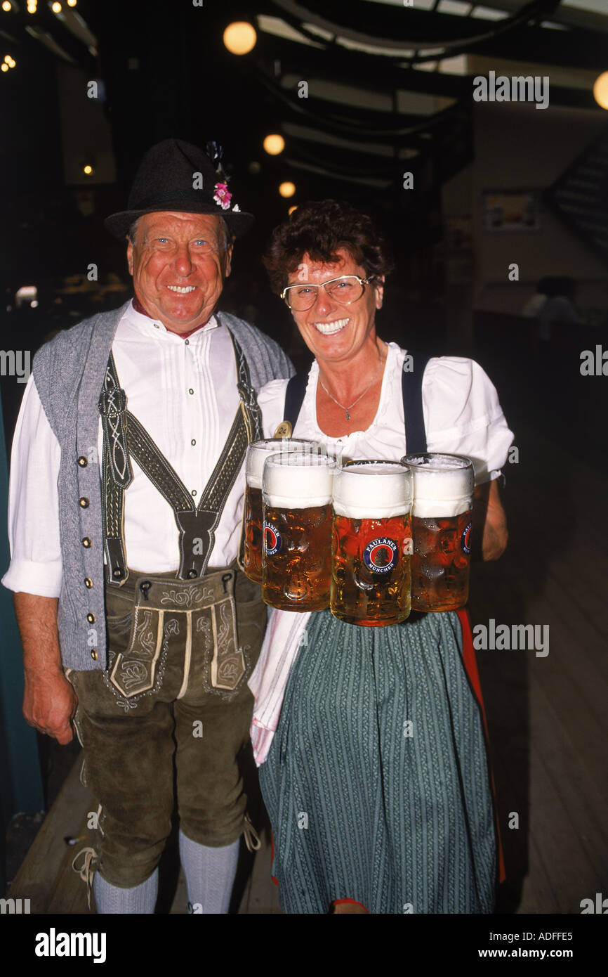 Waitress with glasses of beer and Bavarian man at Oktoberfest in Munich Stock Photo