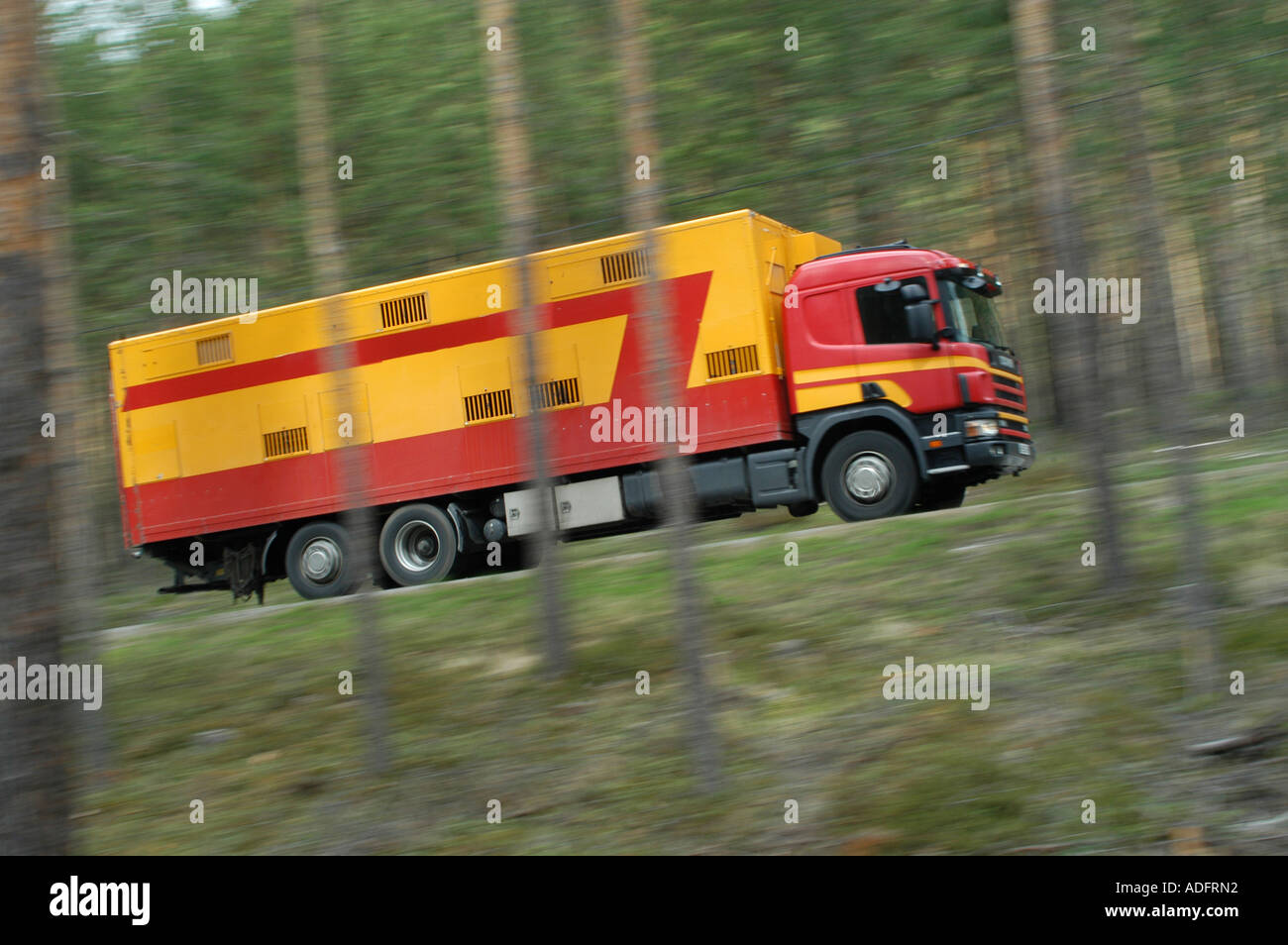 Lorry driving through wooded countryside. Stock Photo