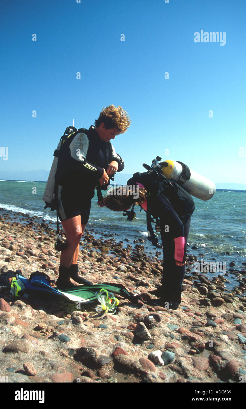 Mother Daughter doing a buddy check prior to scuba diving Dahab Sinai Red Sea Egypt Nicola Francesca Mayes Stock Photo