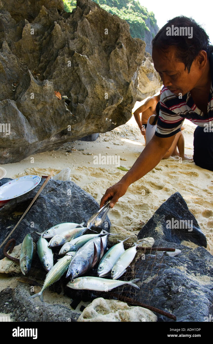 Philippines Luzon Palawan Province El Nido Town Bacuit Bay Fisherman Cooking Fish for Lunch Stock Photo