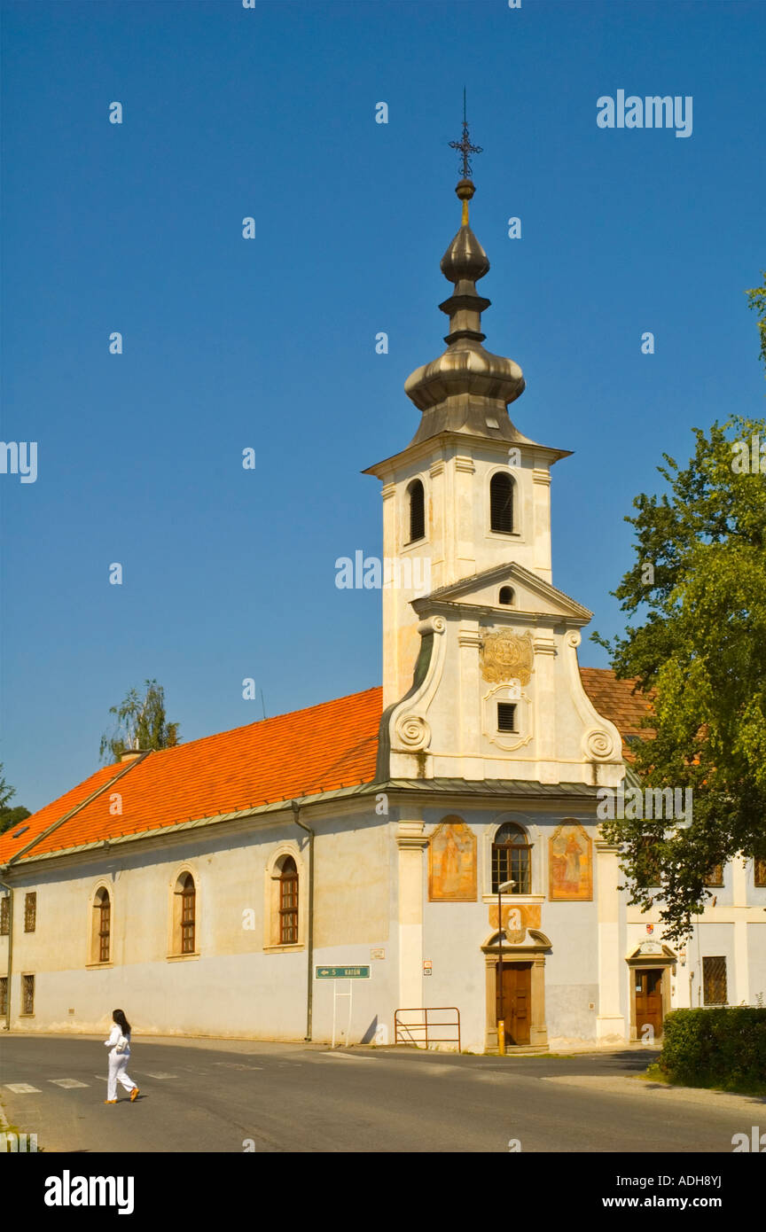 Woman walking past Church of Merciful Brothers in town of Spisske Podhradie in eastern Slovakia EU Stock Photo