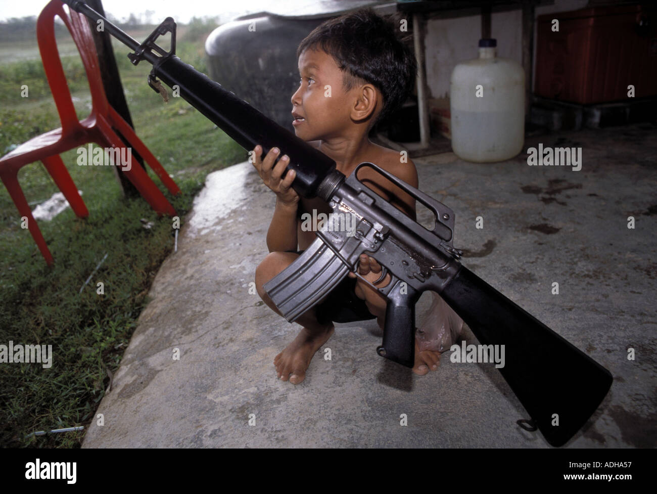 Child holds M16 assault rifle Phnom Penh cambodia PH Dan White Stock Photo  - Alamy