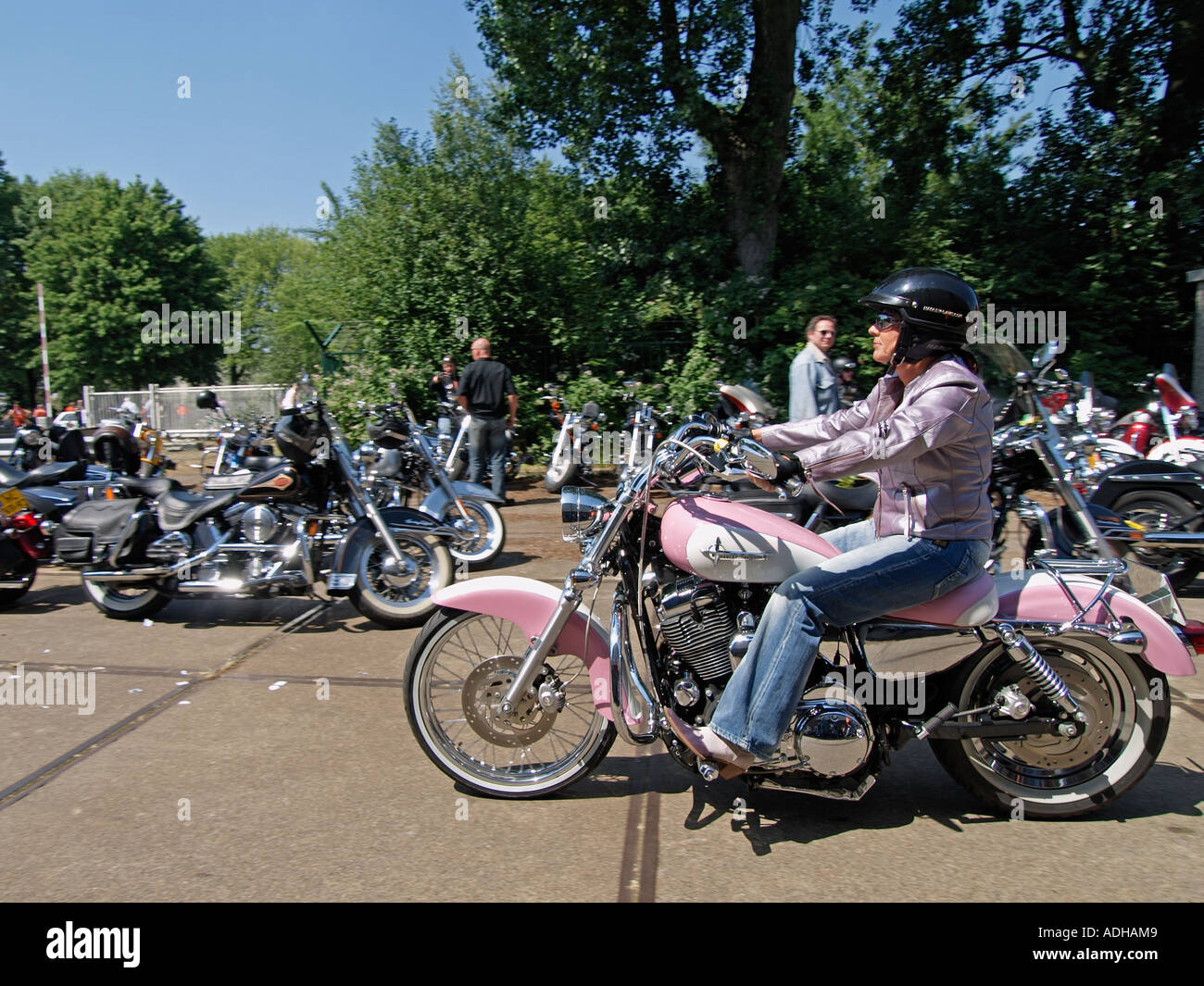 Lady biker on a custom built pink with white Barbie-doll style Harley Davidson motorcycle Breda the Netherlands Stock Photo