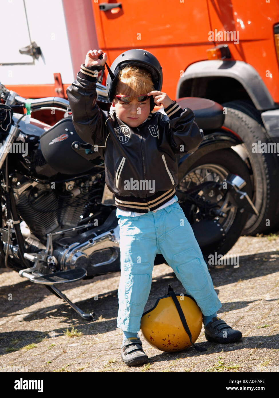 Very young biker boy removing his helmet and sunglasses after a trip with  his dad Breda the Netherlands Stock Photo - Alamy