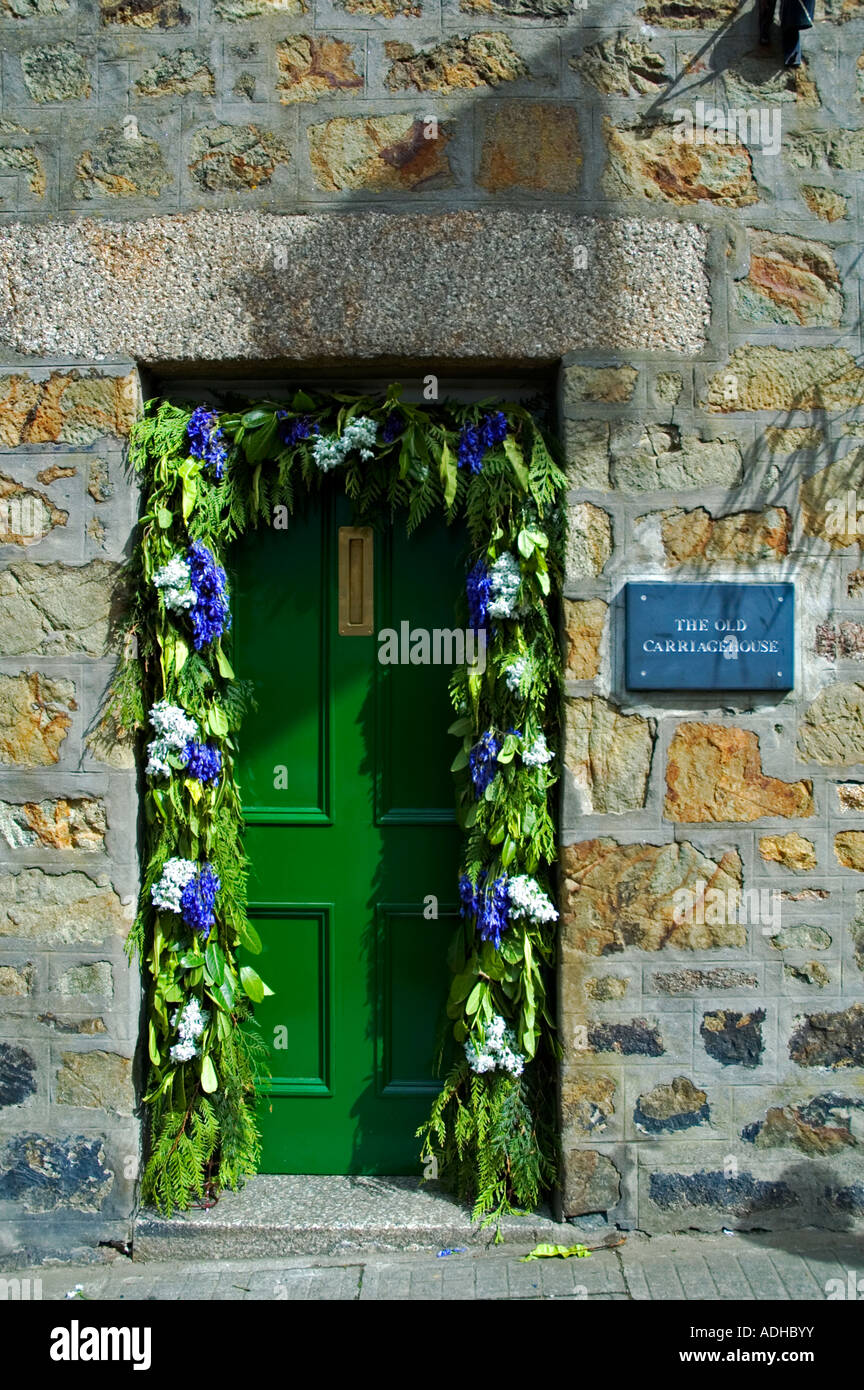 the front door of a house, decorated with flowers on flora day in helston,cornwall,england Stock Photo