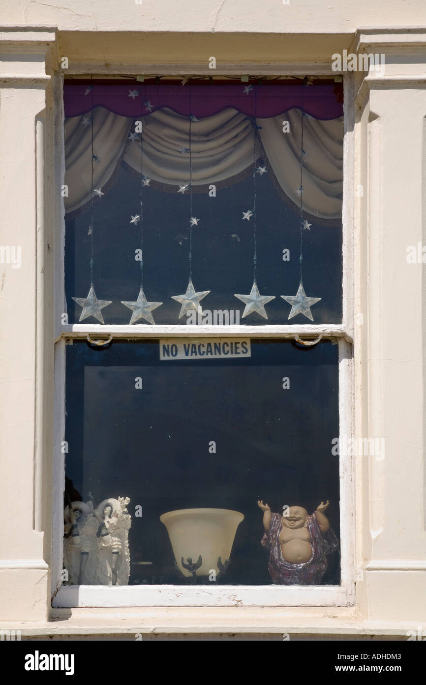 No Vacancies Sign With Cheap Ornaments In Hotel Window