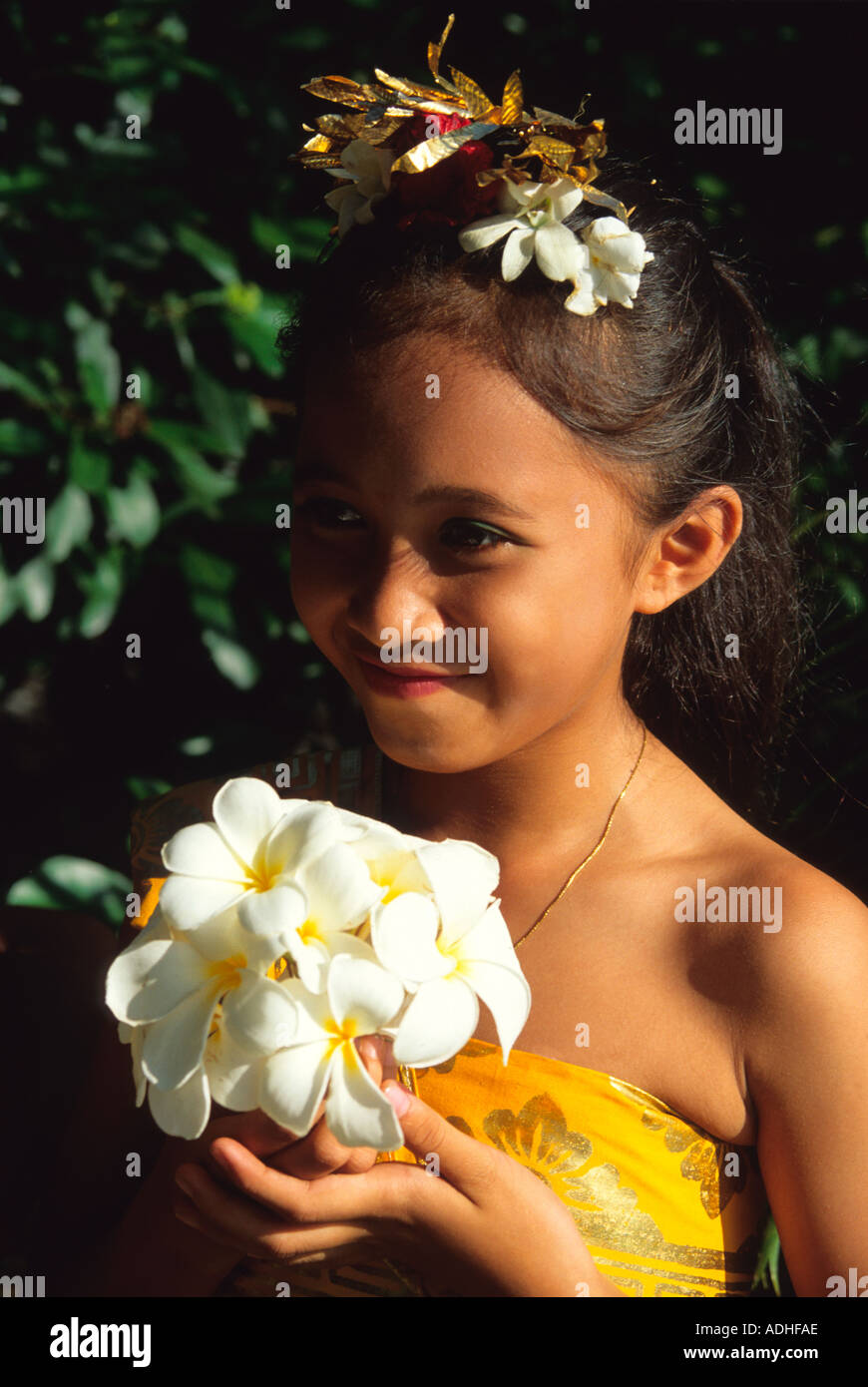 young girl dancer in traditional clothes and frangipani at a Bali religious festival Stock Photo