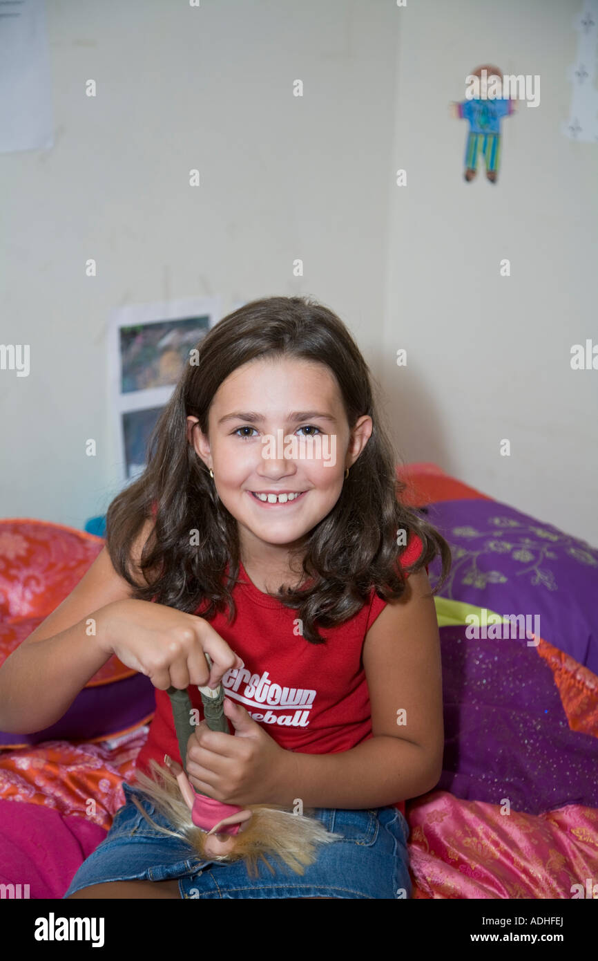 Little Girl Playing with Dolls in her Bedroom Stock Photo