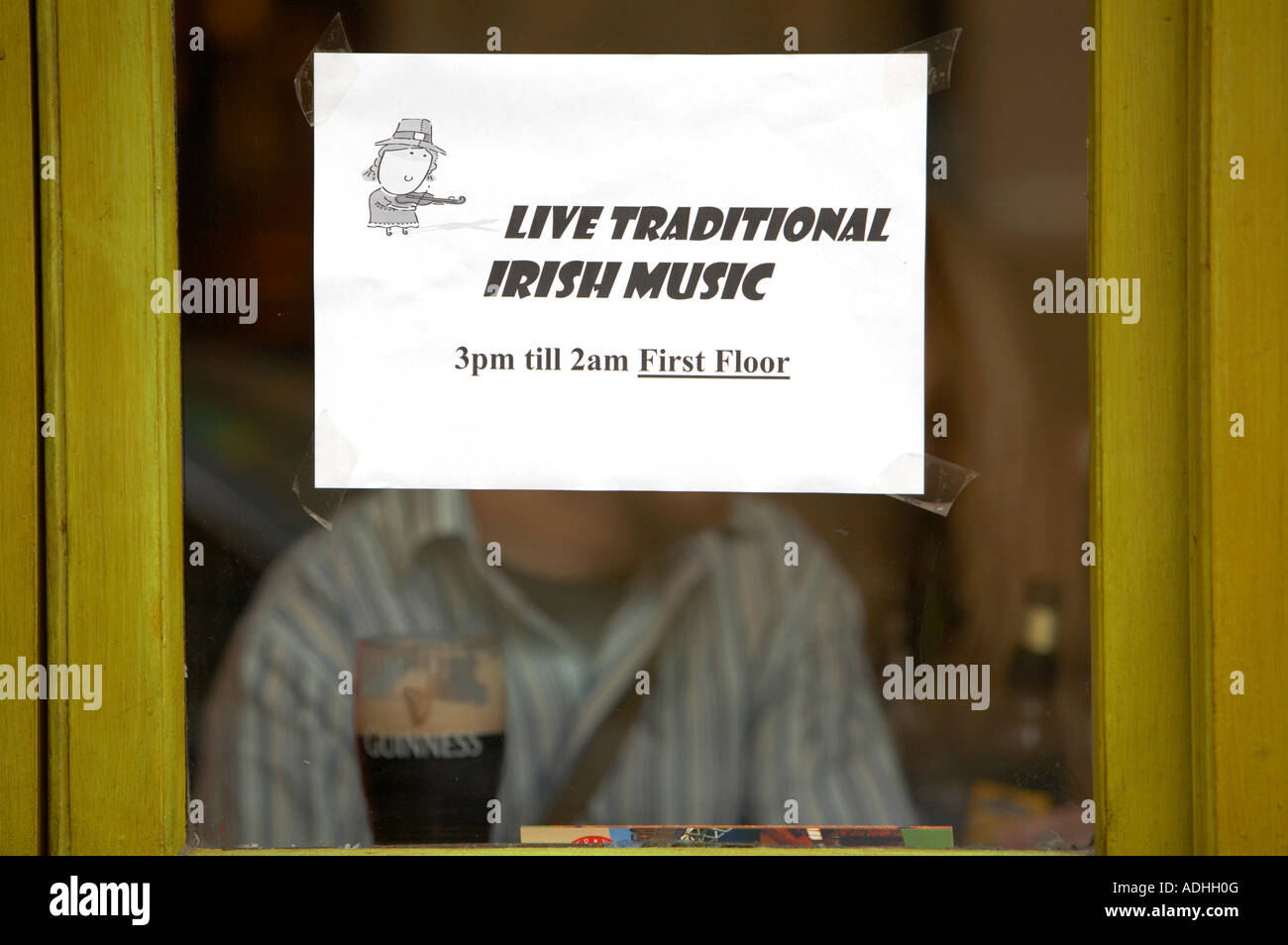 live traditional irish music 3pm till 2am first floor laser printed sign taped to window of pub in dublin with half drunk pint Stock Photo