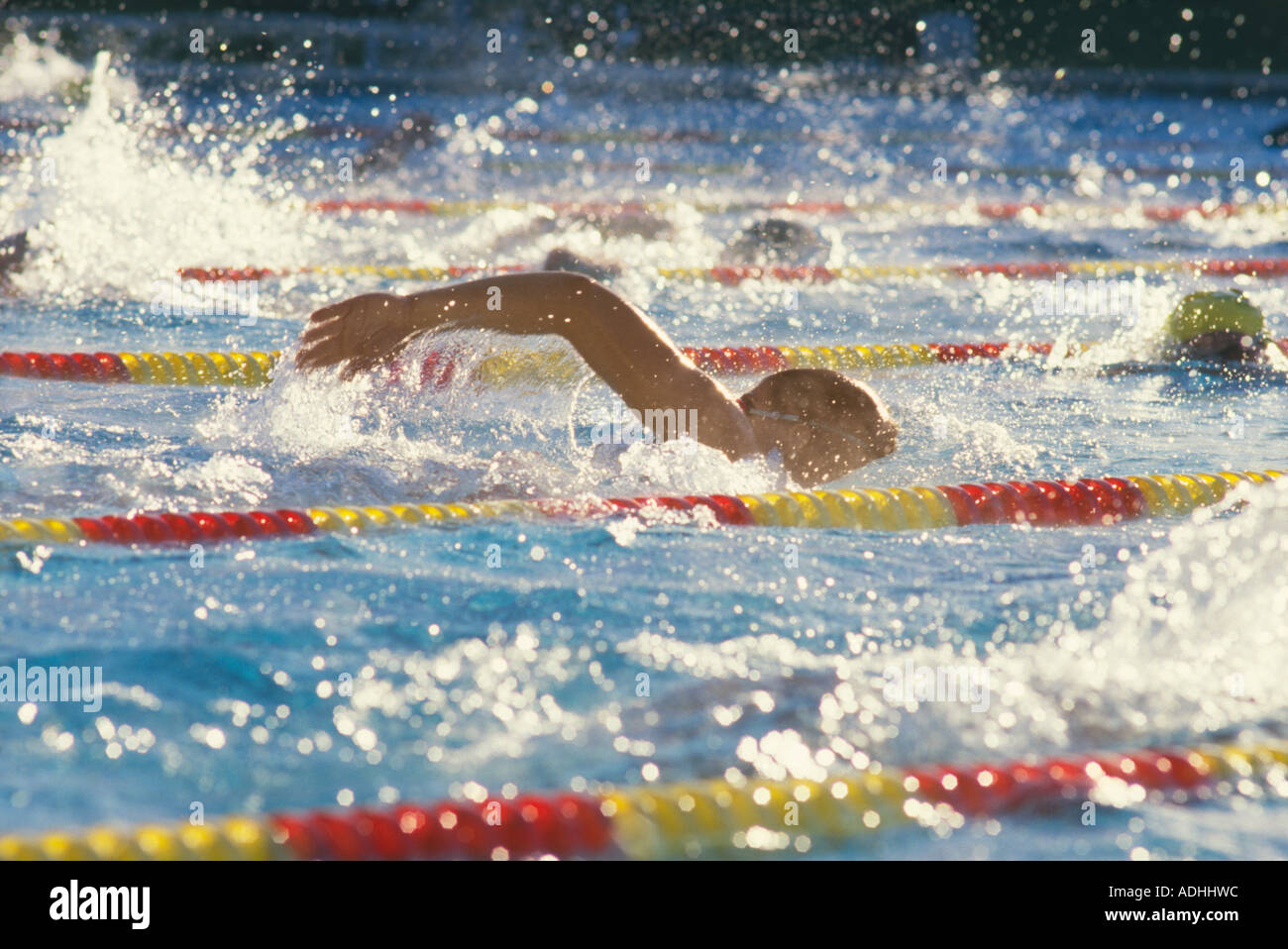 Swimmers racing at competitive swim meet in swimming pool Stock Photo
