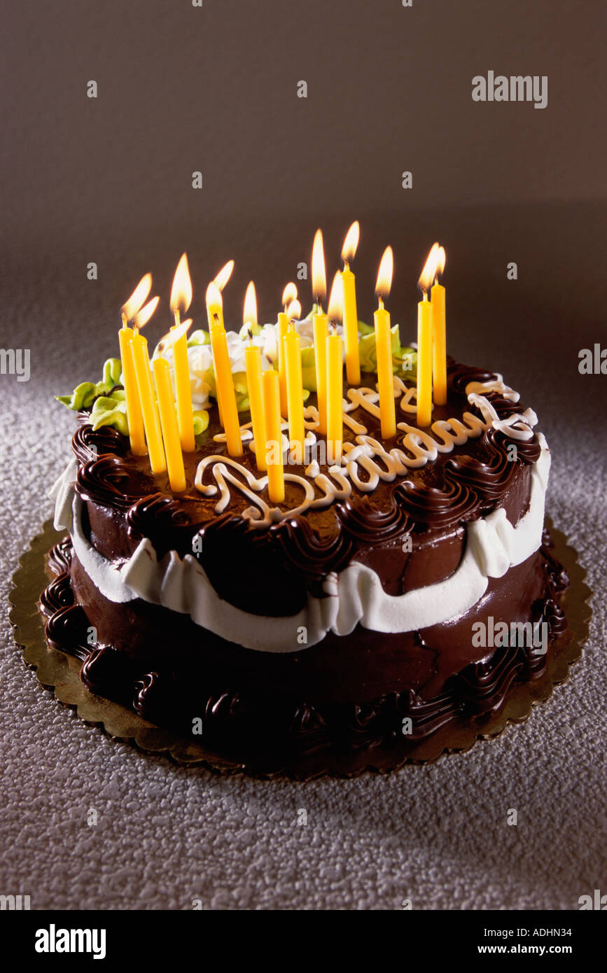 Decorated birthday cake with lit candles Stock Photo - Alamy