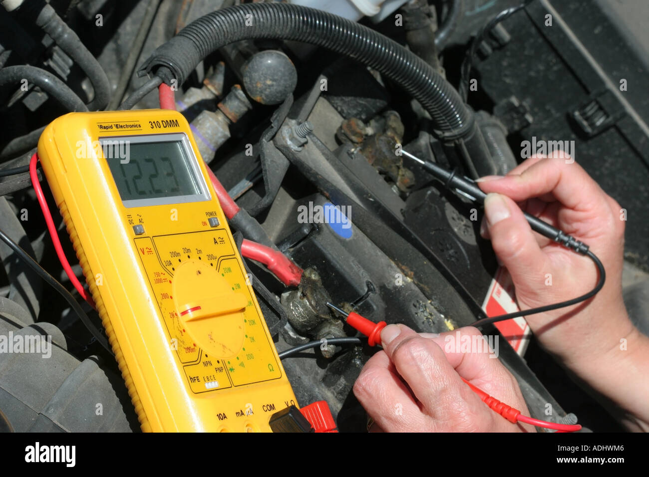 Motor Vehicle Mechanic Checking Battery Voltage Using Multi Meter Stock