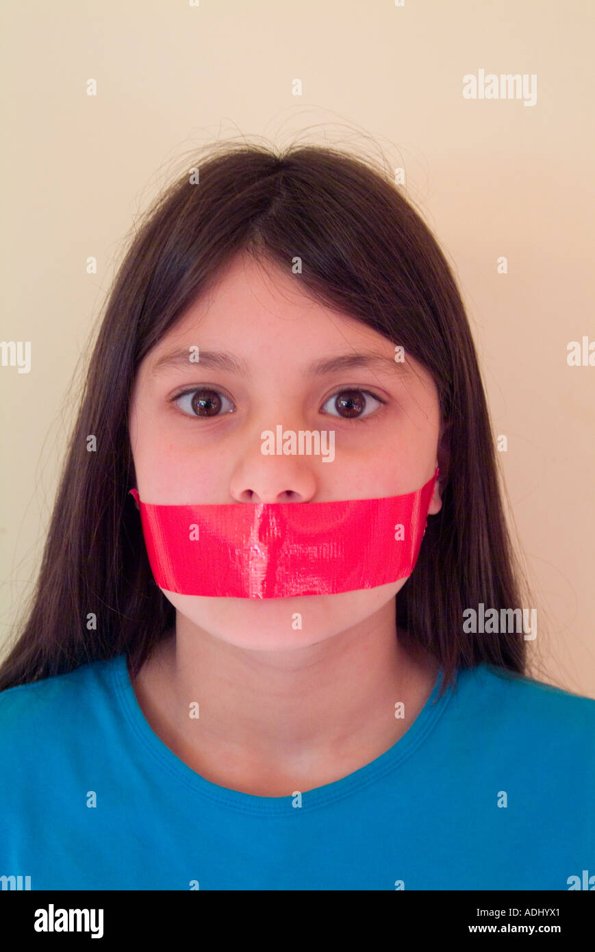 Young girl with tape over her mouth to illustrate suppression of freedom of speech Stock Photo