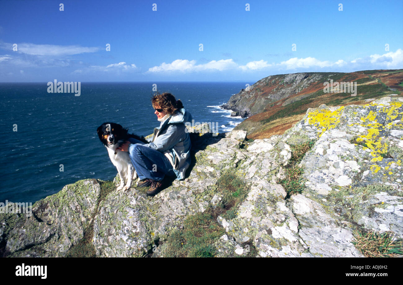 Cliff path above Lantern Rock looking NW toward Bolt Tail between Salcombe and Hope, south Devon. Woman with border collie dog. Stock Photo