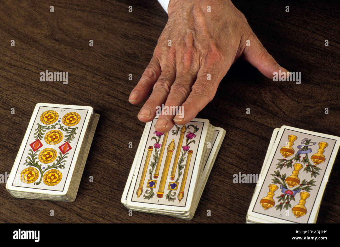 Hand of a fortune teller during a reading of fortune using a tarot deck of cards Stock Photo