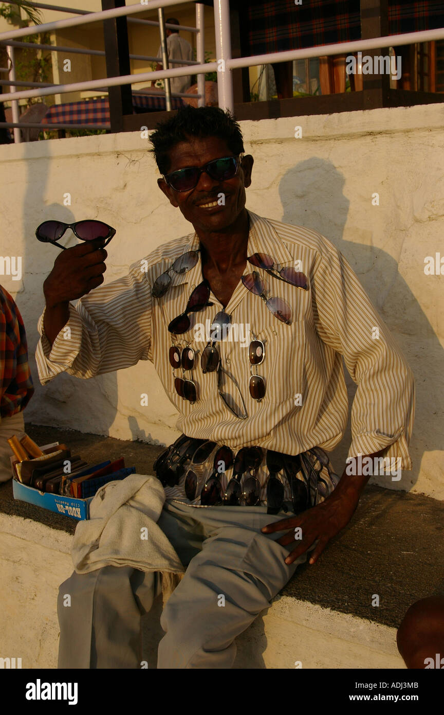 Indian man selling sunglasses along Kovalam beach Stock Photo