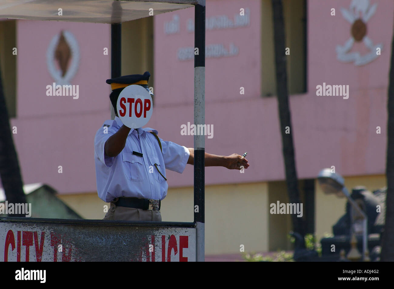 Traffic police man holding stop sign centre of town India Trivandrum. Thiruvananthapuram Kerala South India Stock Photo