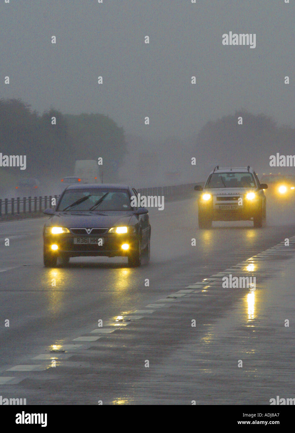 Cars driving in the rain poor visibility on a main road with headlights on Stock Photo Alamy