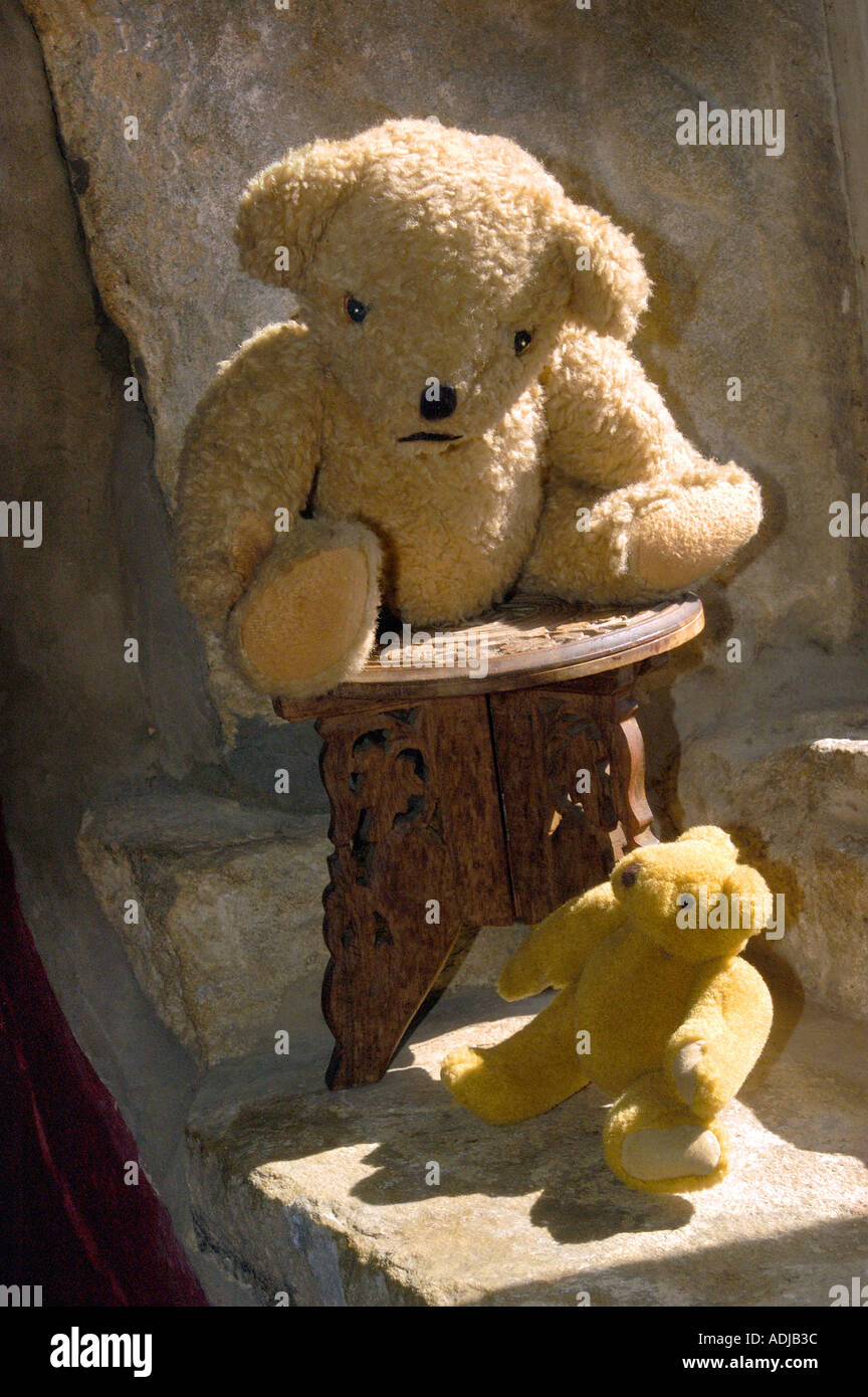 TWO TEDDY BEARS ON STONE WINDOW SILL IN BRIGHT SUNSHINE LOOKING AT EACH