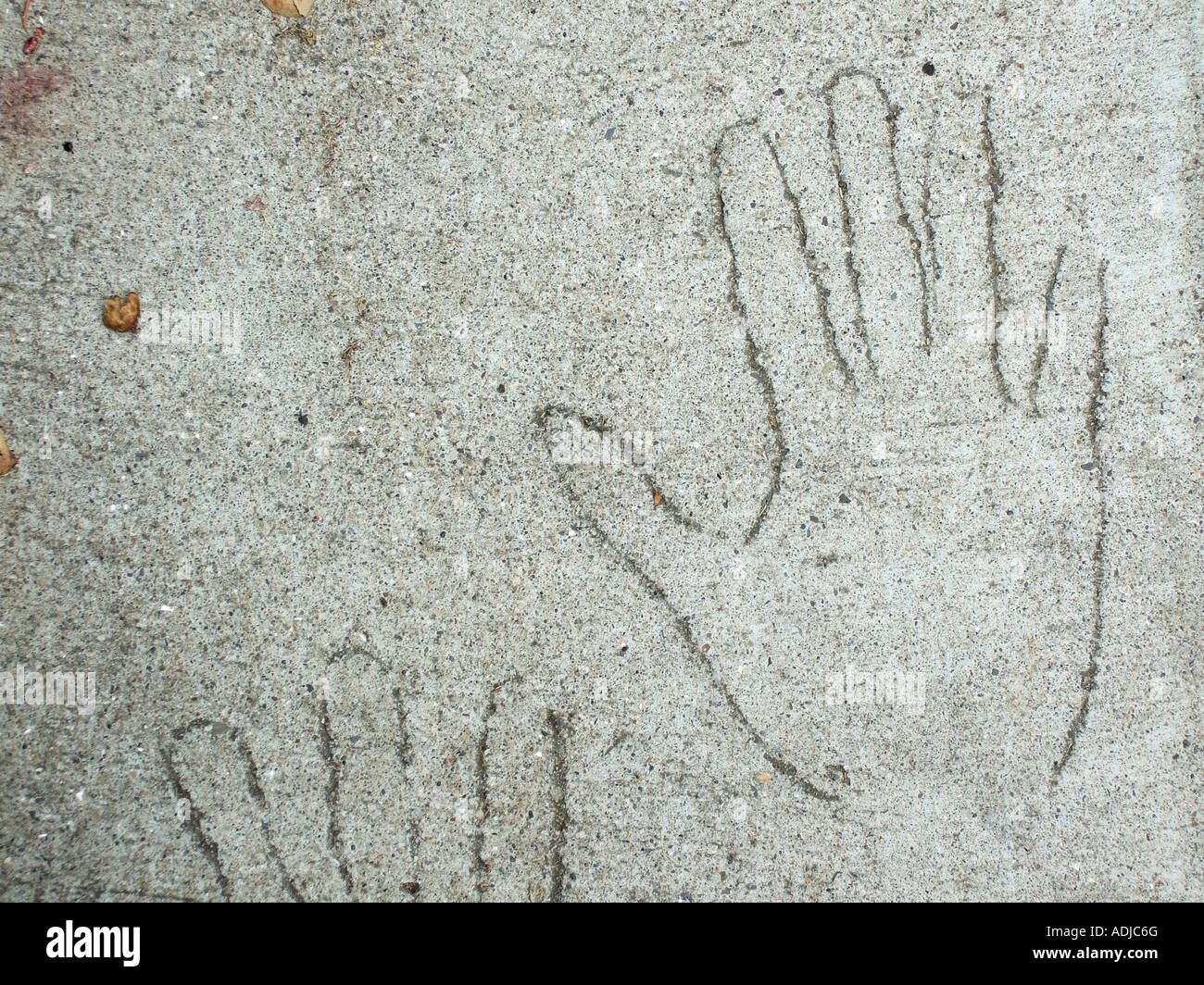 '^Outline of hands scratched in cement on ^sidewalk'. Stock Photo