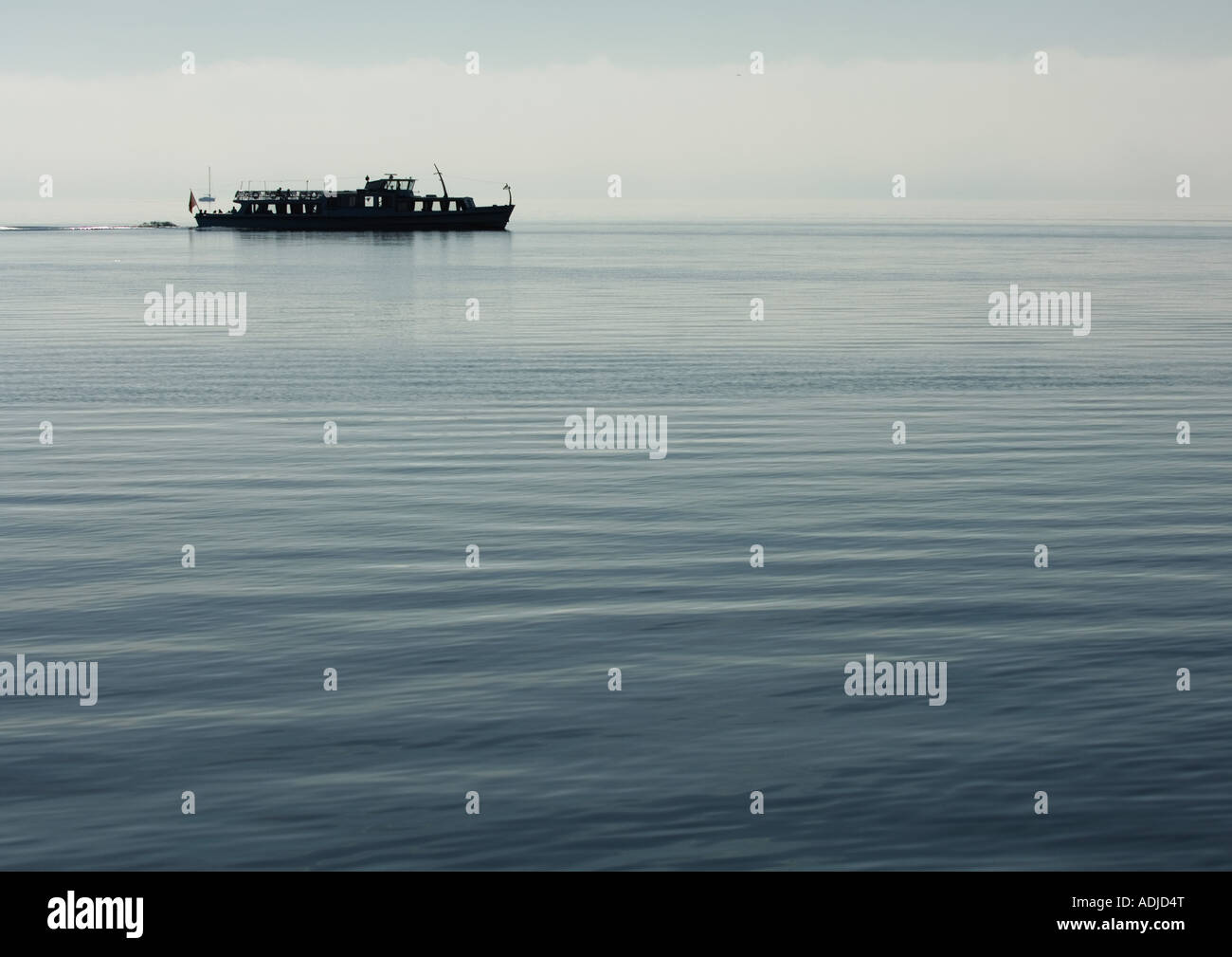 Seascape with silhouette of boat Stock Photo - Alamy