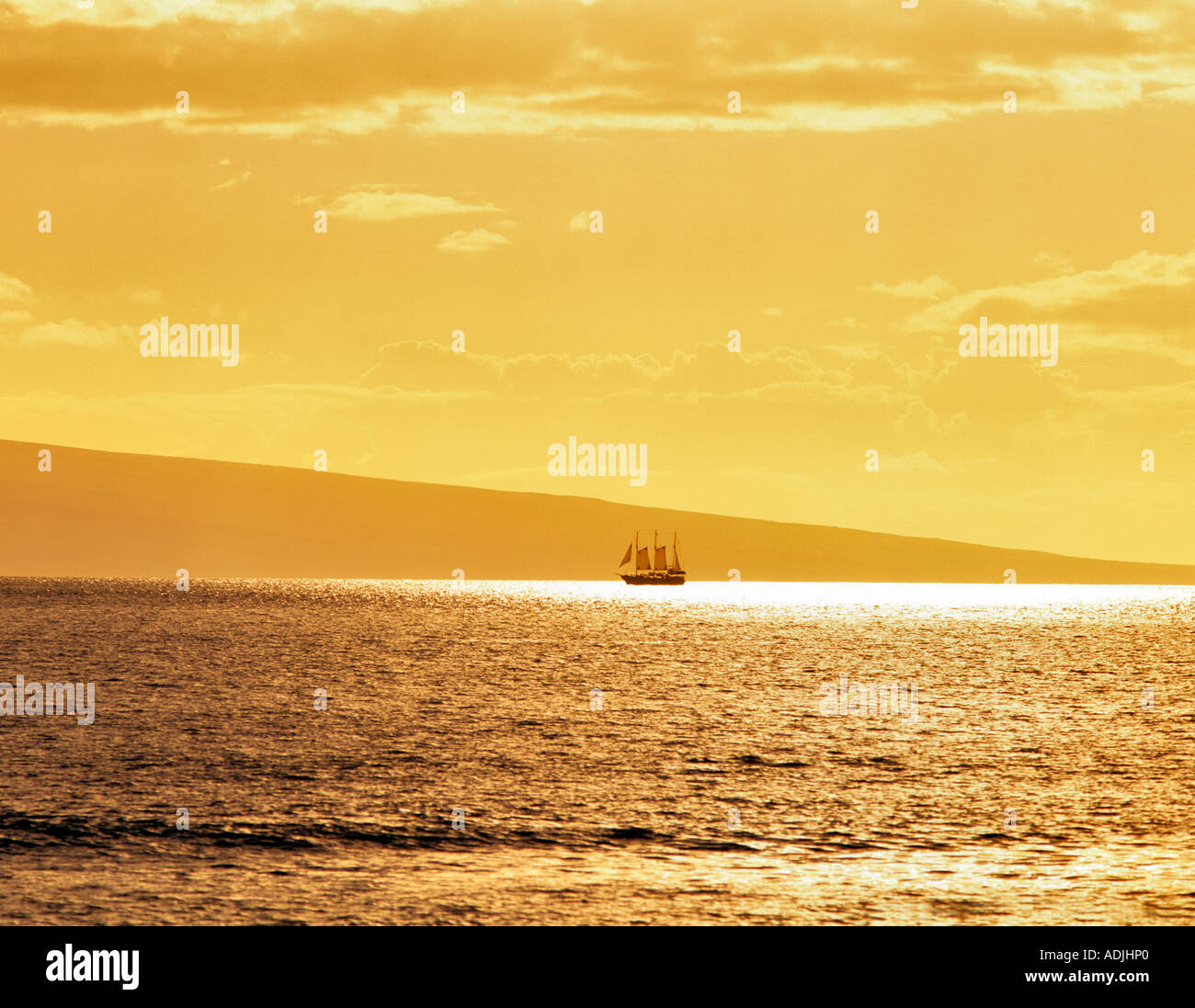 Backlit old time sailing ship at sunset Island of Lanai in back Shot from Maui Hawaii Stock Photo