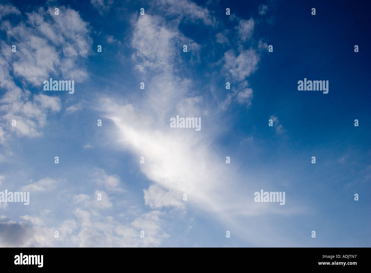 Sun shining through the clouds against a blue background Stock Photo