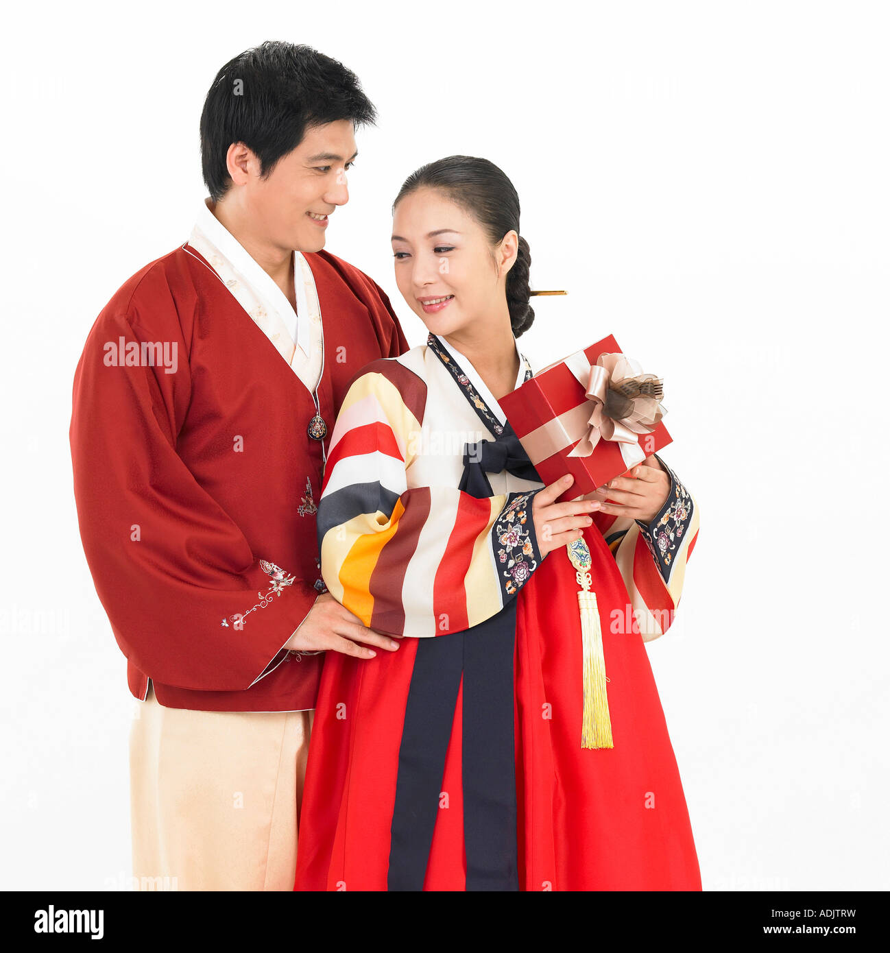 A Korean man and a woman wearing Hanboek is holding a gift box Stock Photo