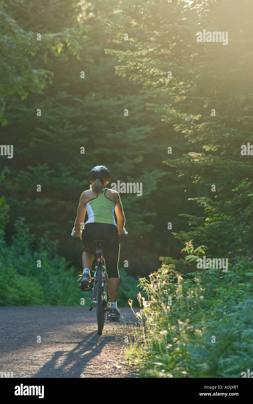 Mapleton park moncton new brunswick with woman bicycling into the setting sun Stock Photo