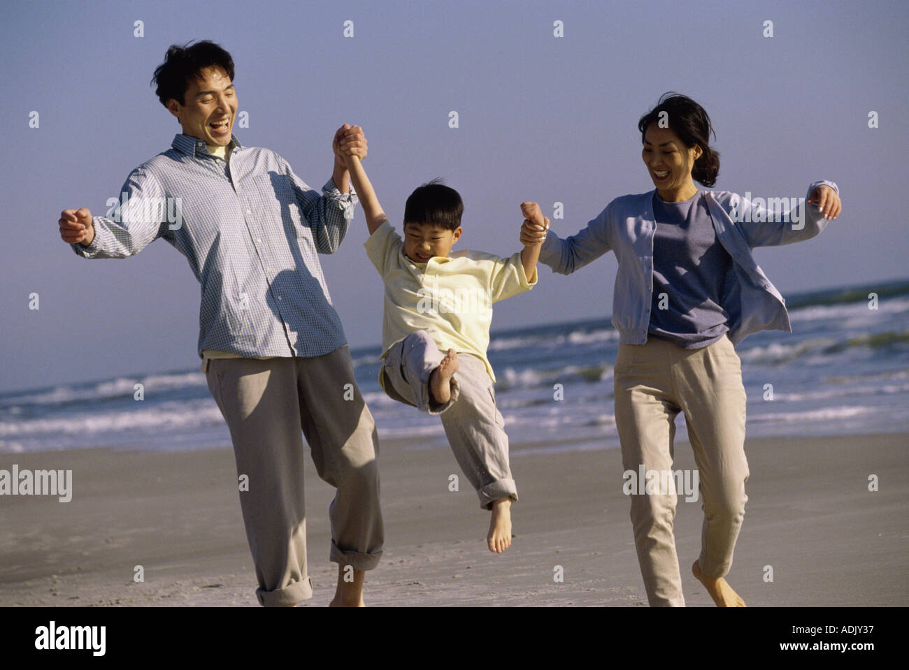 Child swinging from parents hands hires stock photography and images
