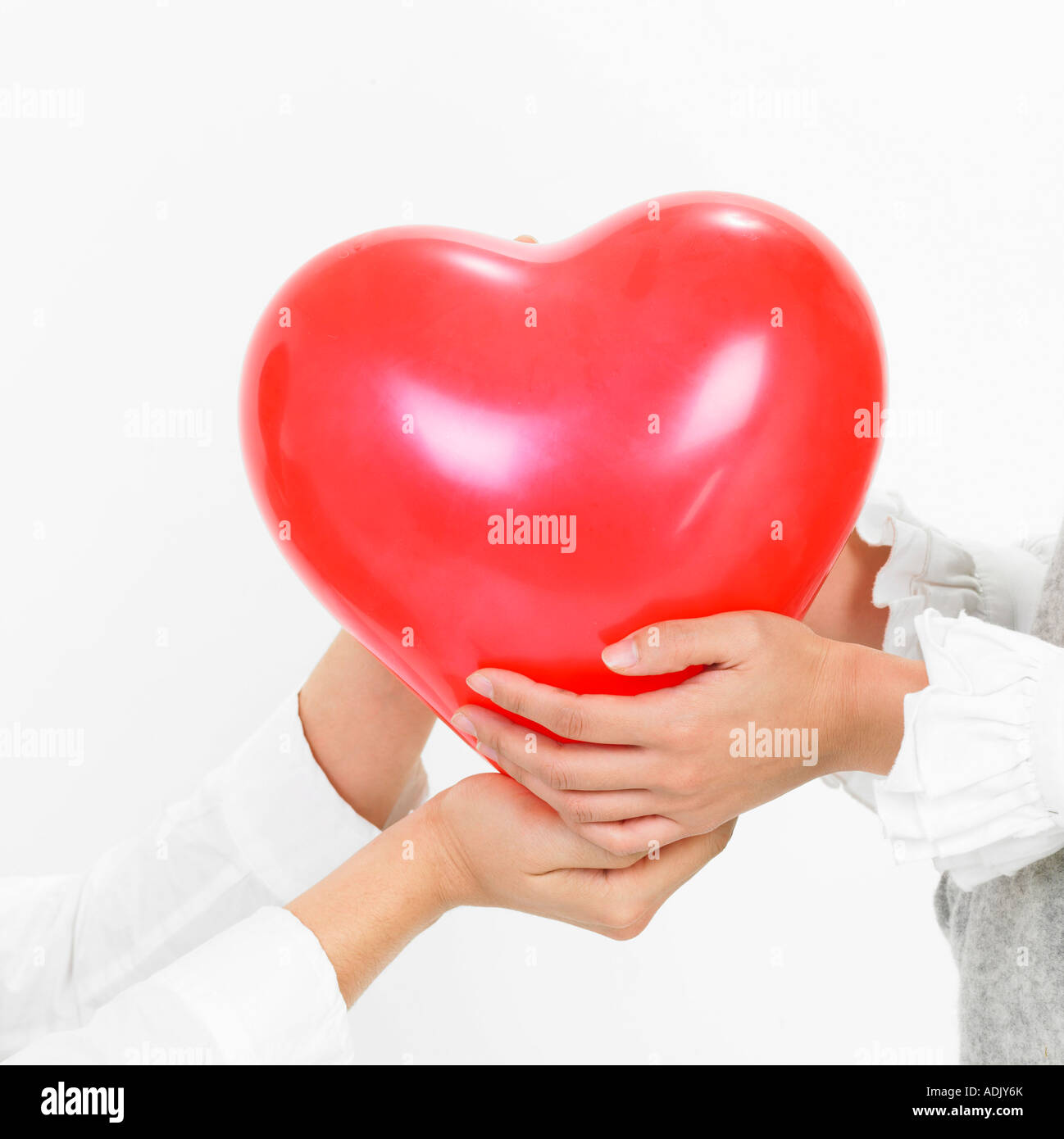 A couple's hands holding a heart balloon Stock Photo - Alamy